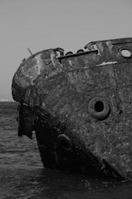 A close-up of a damaged ship hull with rust and impact marks from a recent collision.