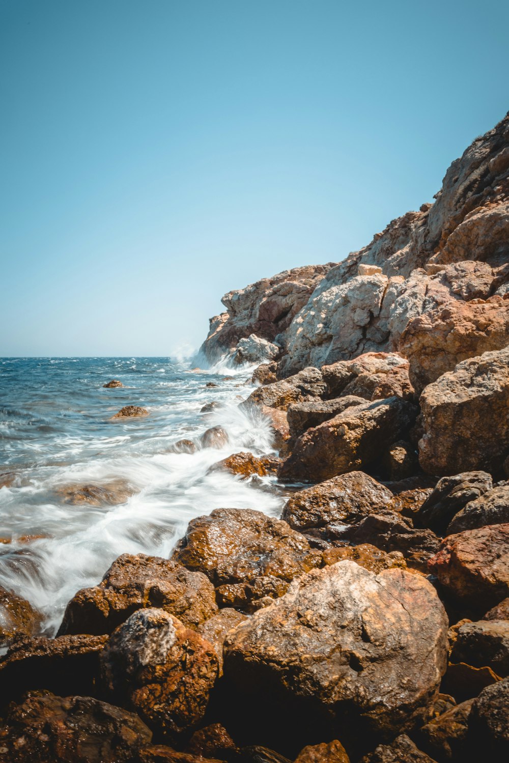 a rocky shore with waves crashing against the rocks