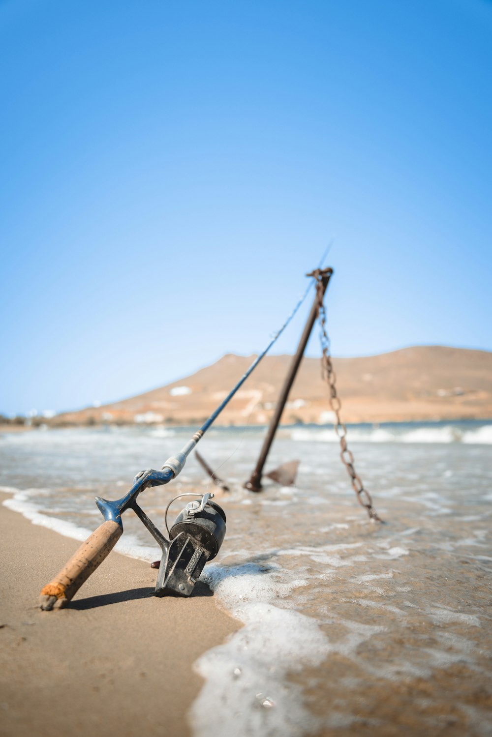 a fishing rod and a reel on the beach
