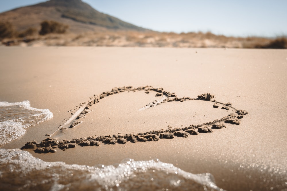 a heart drawn in the sand on a beach