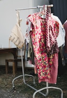 A vibrant dress from gazellee hanging on a rustic wooden rack.