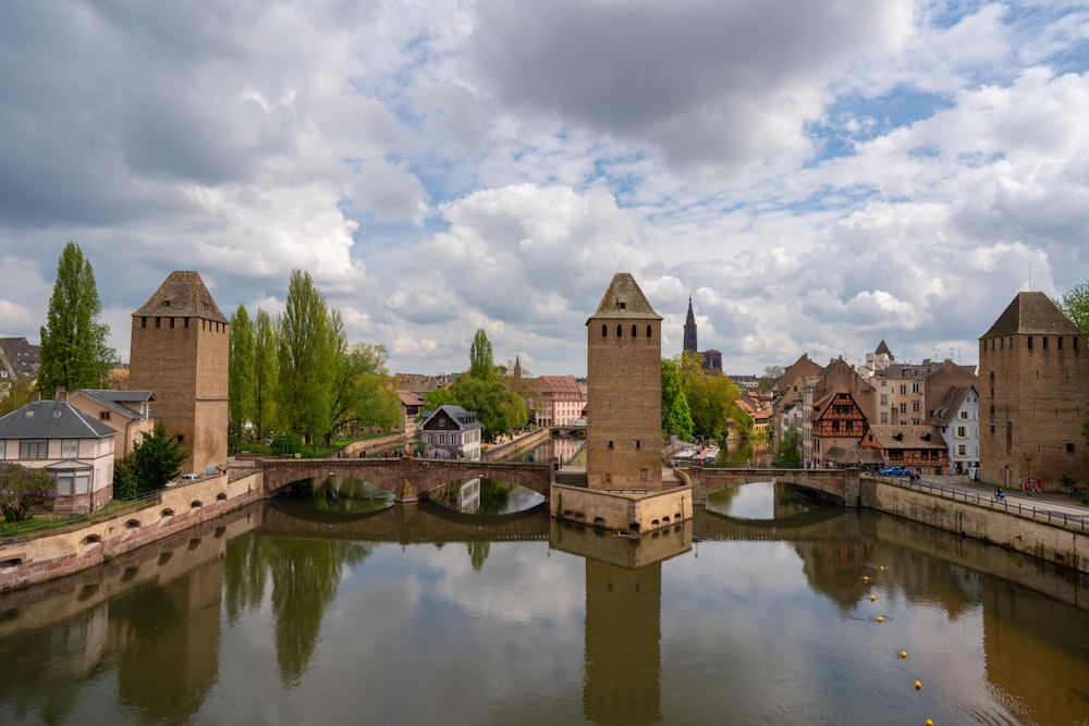 a river running through a small town under a cloudy sky