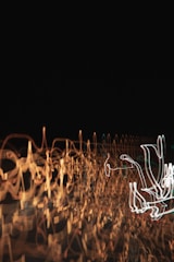 Abstract dynamic light artwork glowing gently against a dark architectural backdrop.