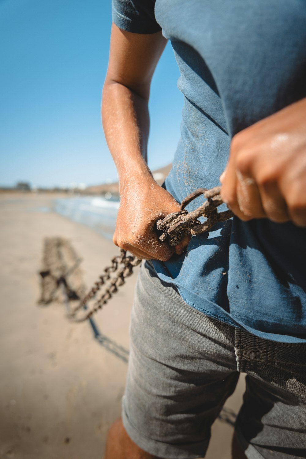 a man holding a chain on the beach