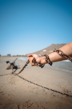 a person holding a chain on a beach