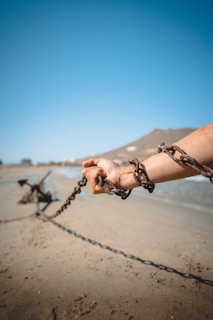 a person holding a chain on a beach