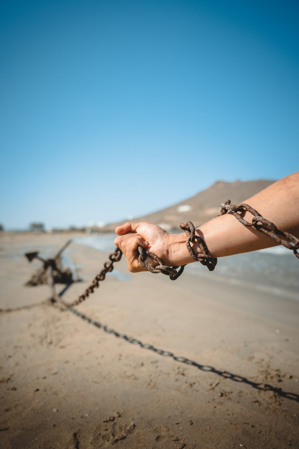a person holding a chain on a beach