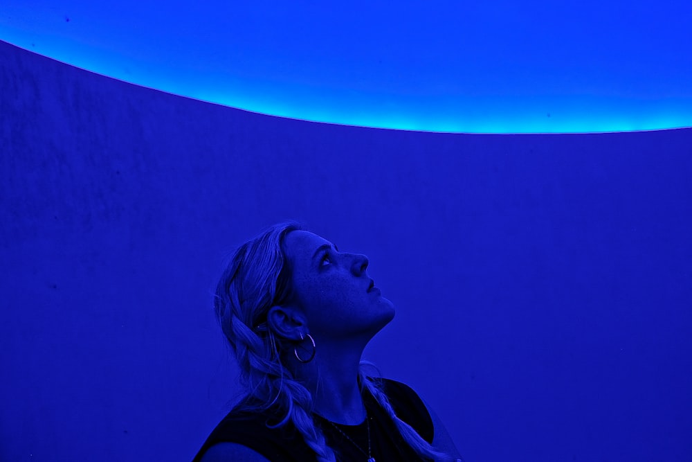 a woman standing in front of a blue wall