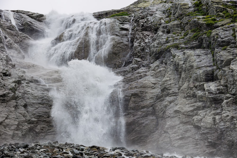 a large waterfall with water cascading down it's sides