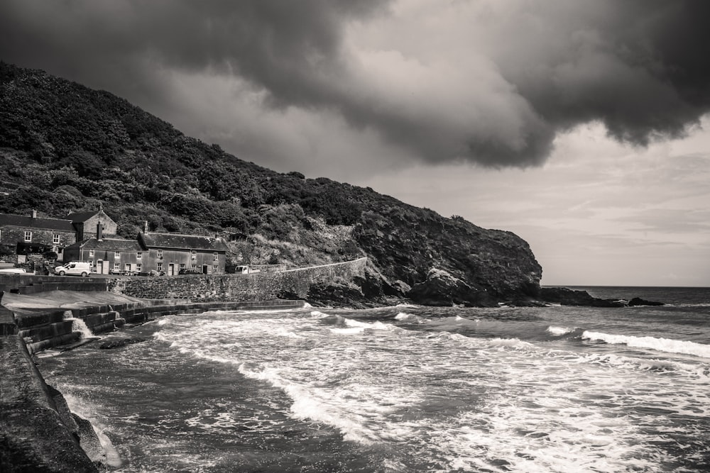 a black and white photo of the ocean and a small town