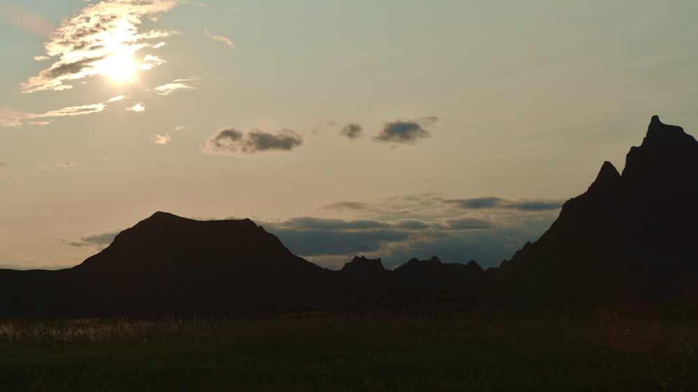 the sun is setting over a mountain range