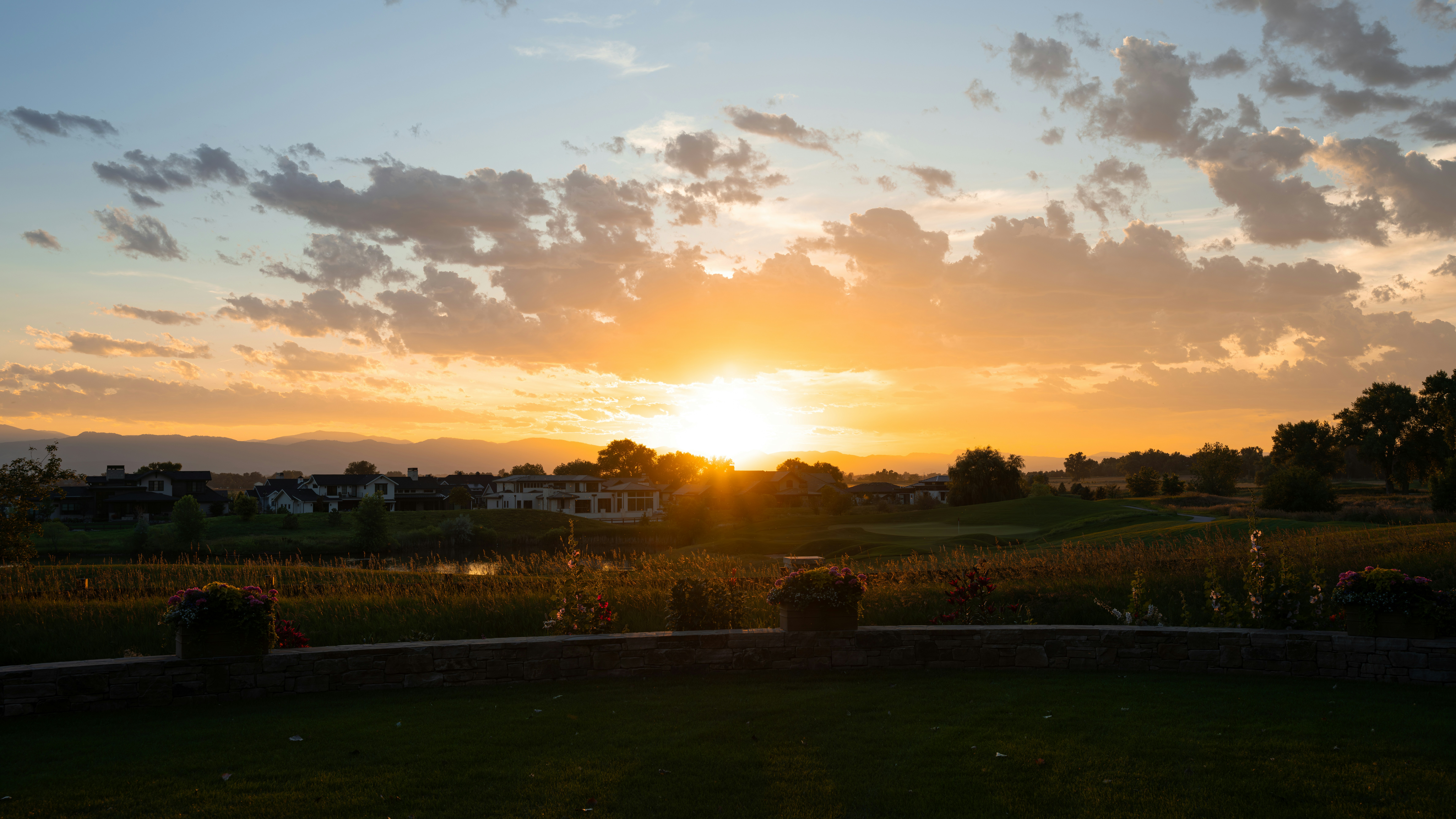 the sun is setting over a golf course