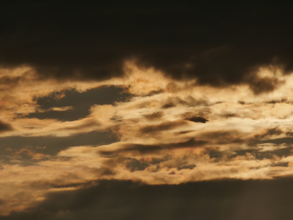 Un avión volando a través de un cielo nublado al atardecer