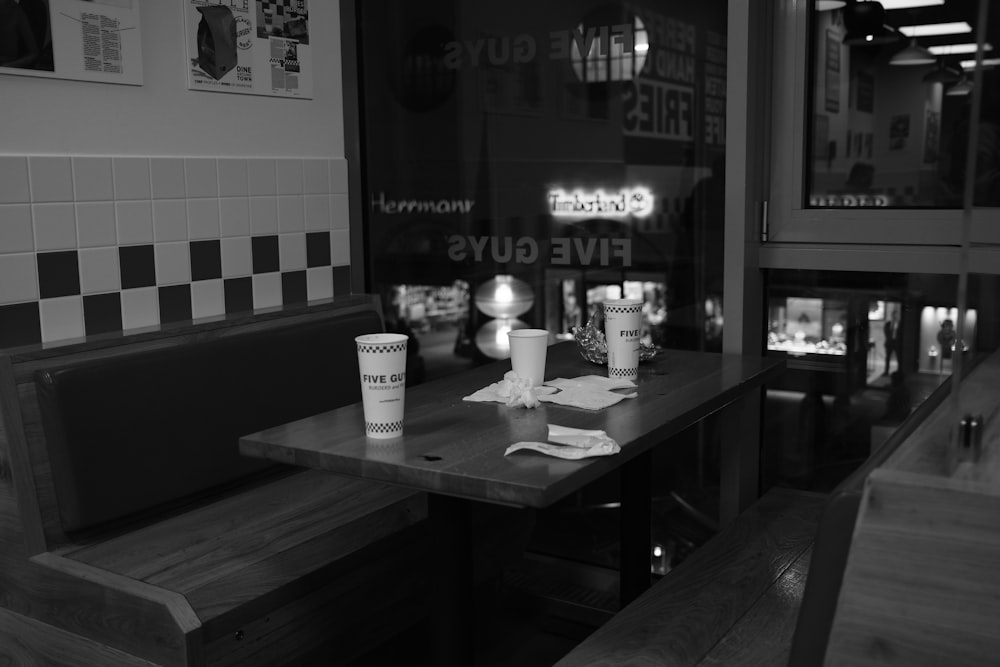 a black and white photo of a table with a cup of coffee