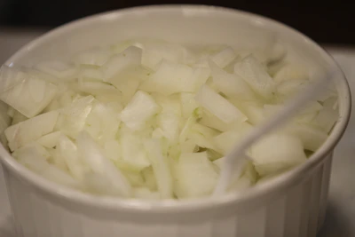 Industrial machinery processing fresh onions into fine powder under hygienic conditions.