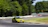 A thrilling shot of a race car speeding through a sharp corner on a sunny day.