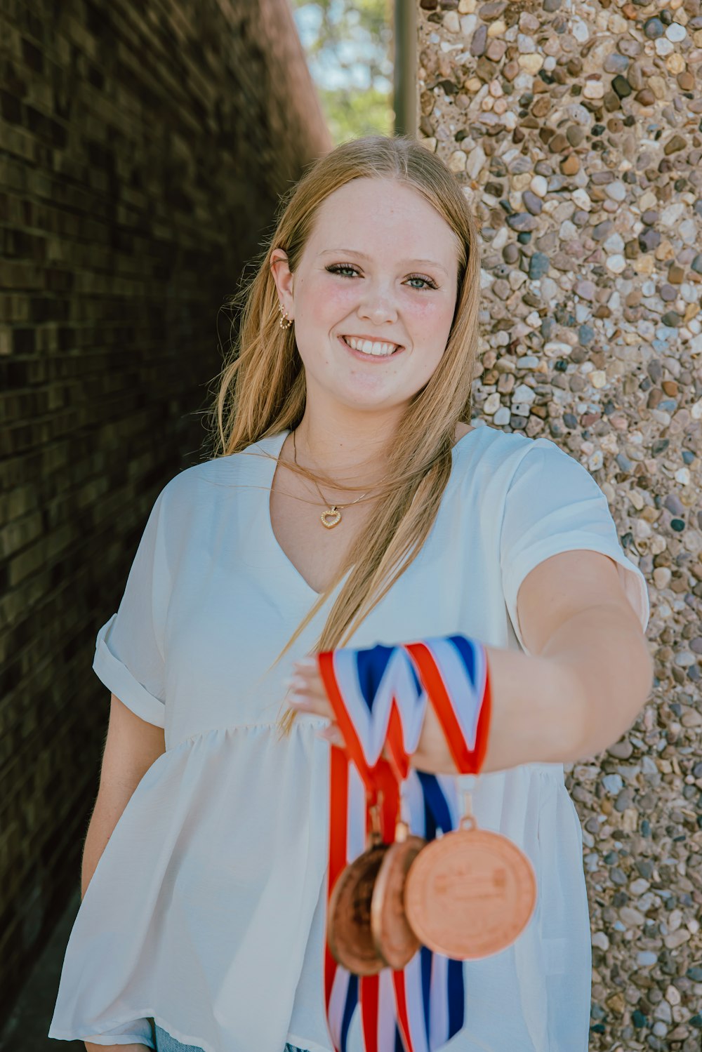 a woman holding a medal and a medal in her hand