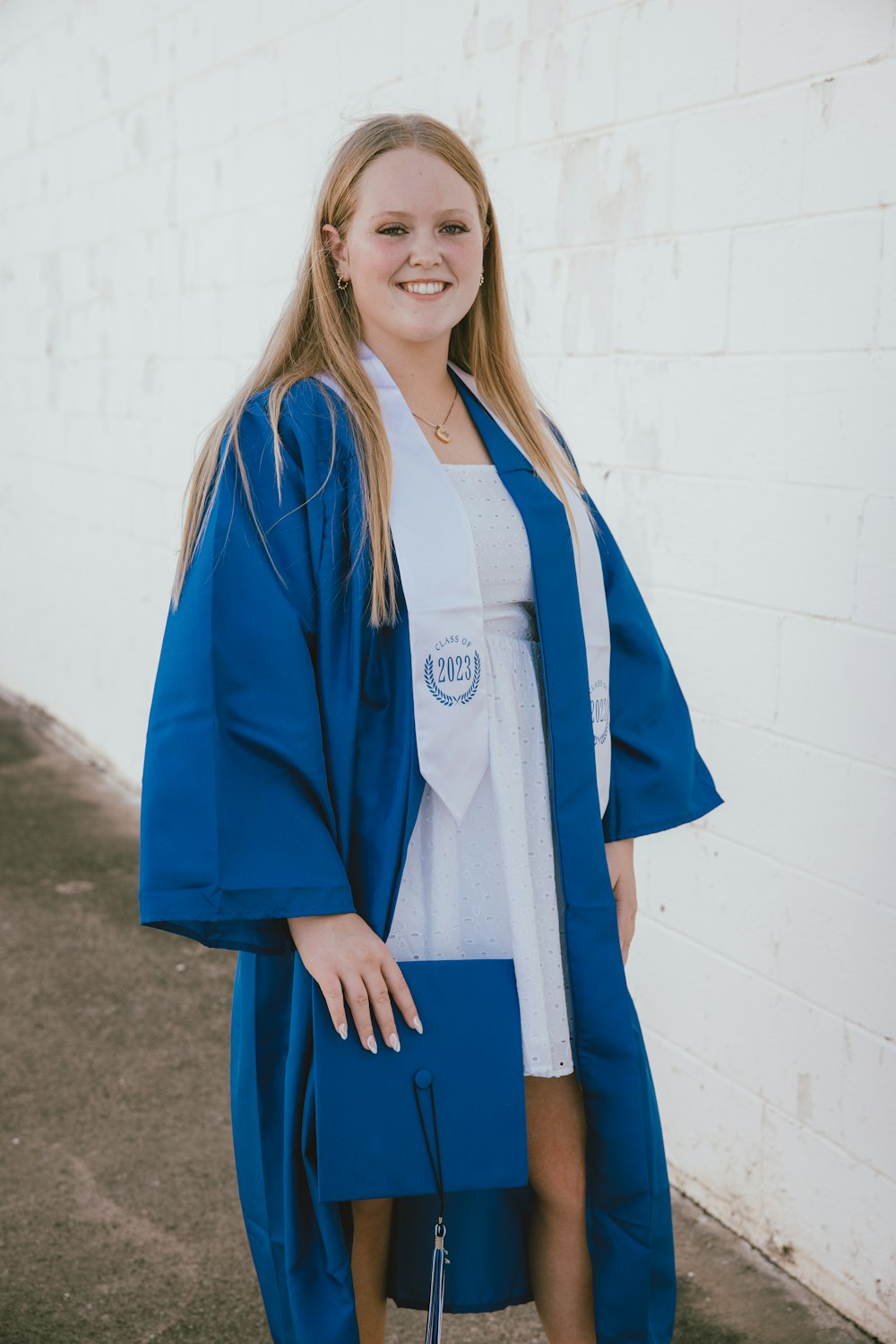 Una donna in un abito blu di laurea in posa per una foto