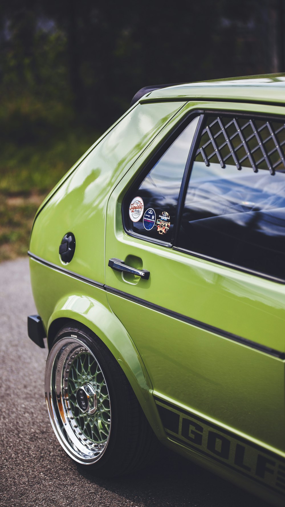 a green car parked on the side of a road