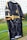 A black sports jersey with a marbled white pattern hangs on a net fence. The jersey features yellow accents on the sleeves and collar, and logos in yellow on the front and side. The background includes a blurred, grassy field.