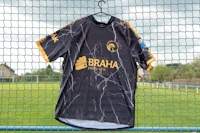 Zwart-geel shirt aan een hek