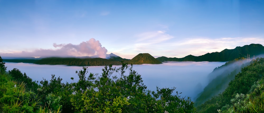 a view of a mountain range with mist in the air