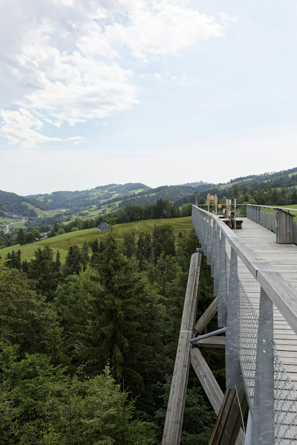 a wooden bridge over a lush green valley