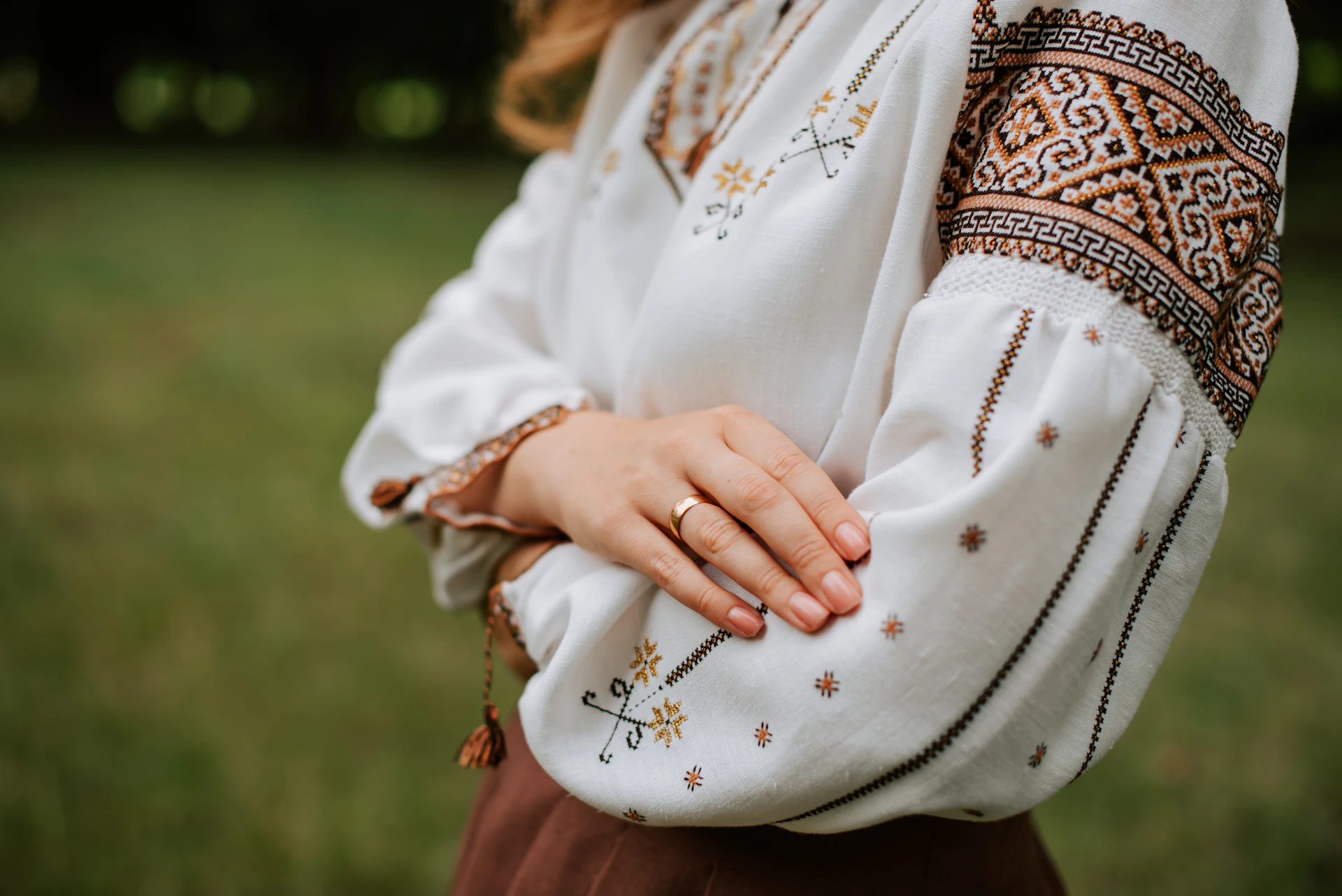 a woman wearing a white blouse and brown pants