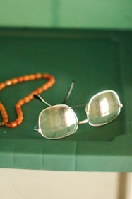 a pair of glasses sitting on top of a green table