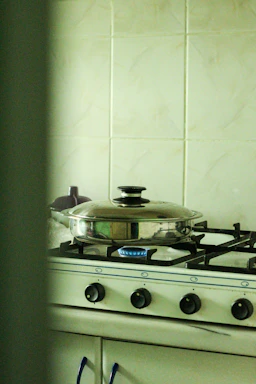 A friendly technician fixing a gas stove in a cozy Mumbai kitchen.