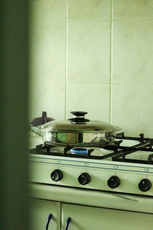 Professional technician examining a gas stove in a modern kitchen setting.