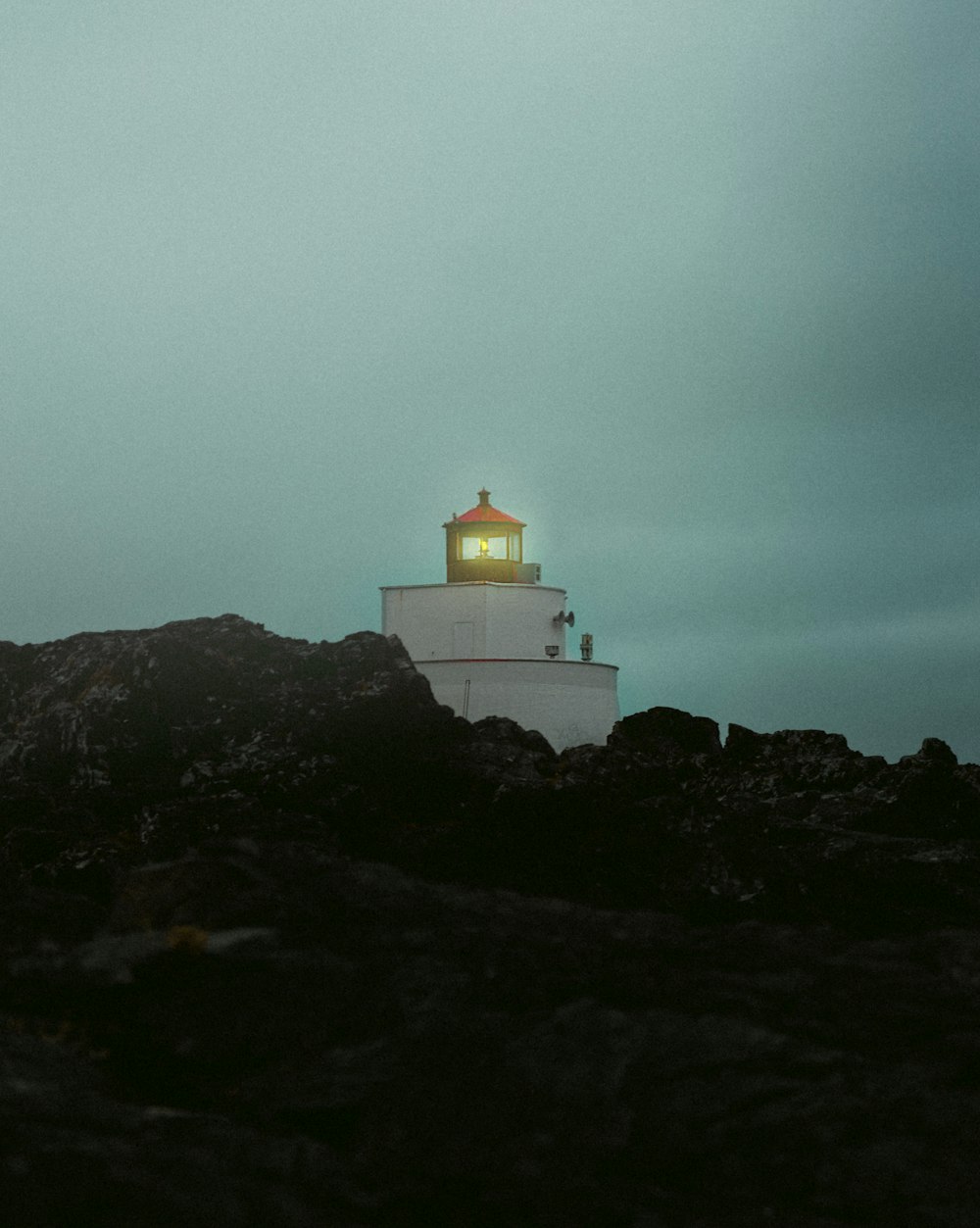 a lighthouse on top of a rocky outcropping