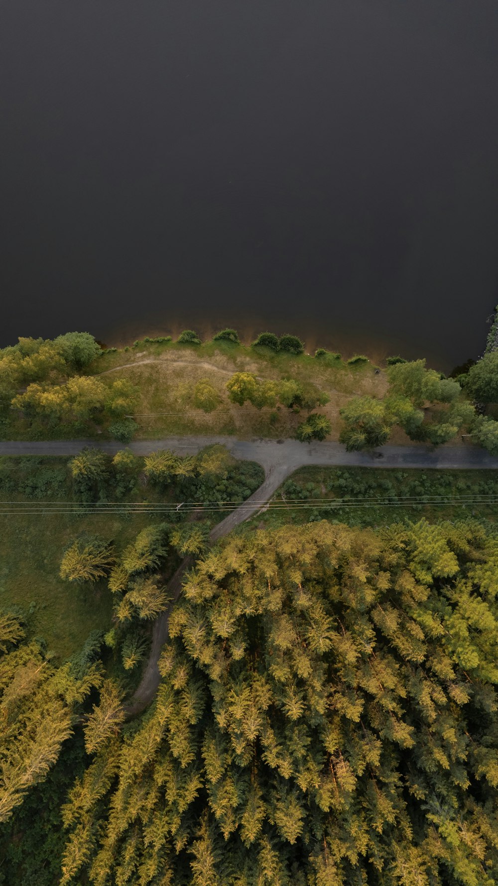 an aerial view of a road surrounded by trees