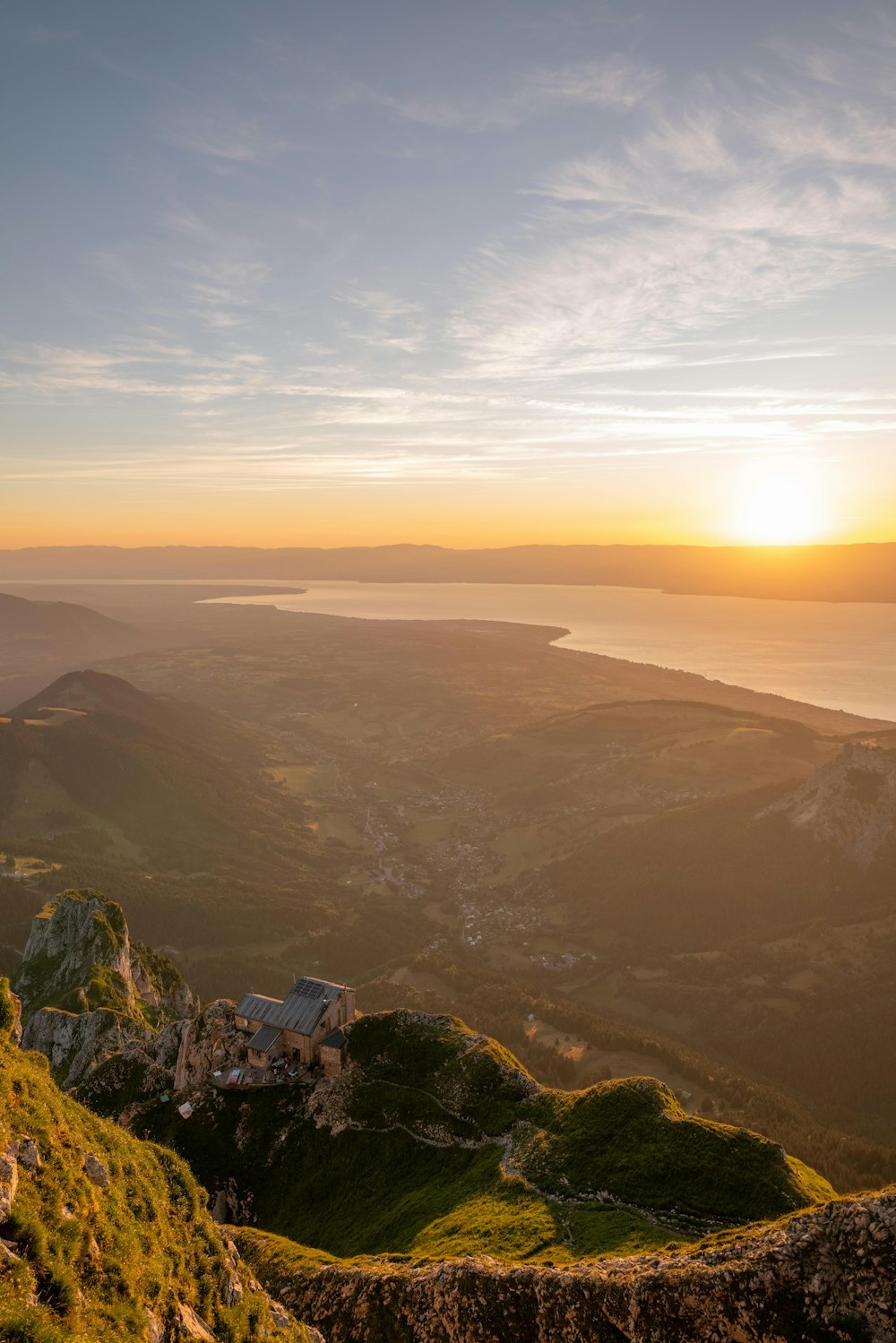 the sun is setting over the mountains and a body of water