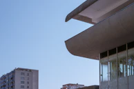 Modern factory buildings with clean lines and reflective glass facades against a clear blue sky.