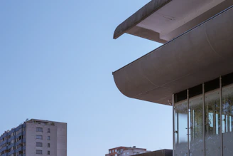 Modern architectural building with clean lines and large glass windows under a clear sky.