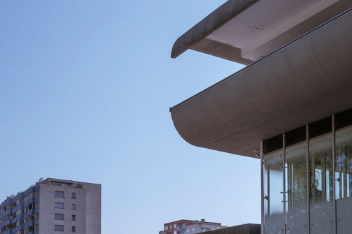 Modern architectural building with clean lines and large glass windows under a clear sky.