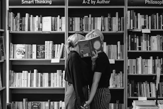 a couple sharing an intimate moment at a book store using a book to cover their faces