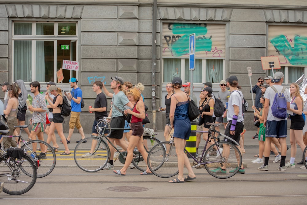 a group of people walking down a street with bikes