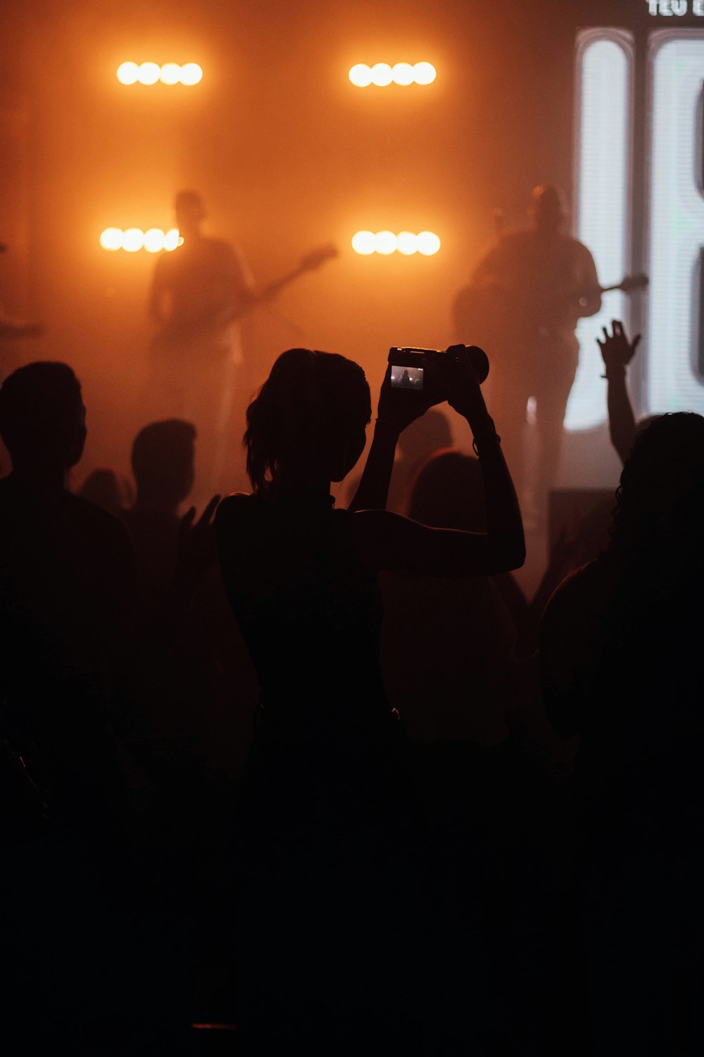 a person taking a picture of a concert with a cell phone