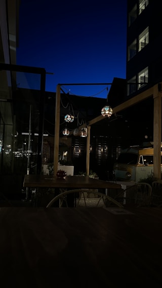 A cozy outdoor dining setup under a starlit sky with traditional Ladakhi lanterns casting a warm glow.