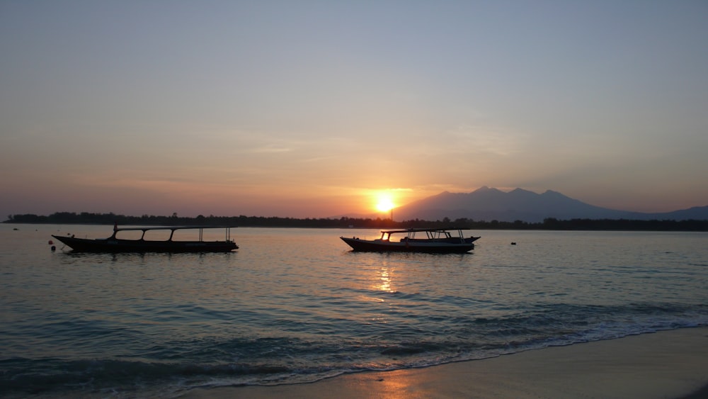 a couple of boats floating on top of a body of water