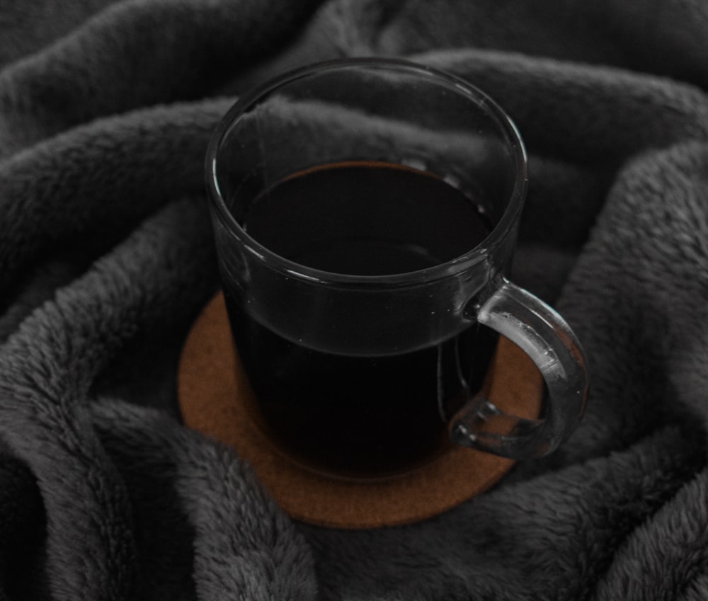a cup of coffee sitting on top of a blanket
