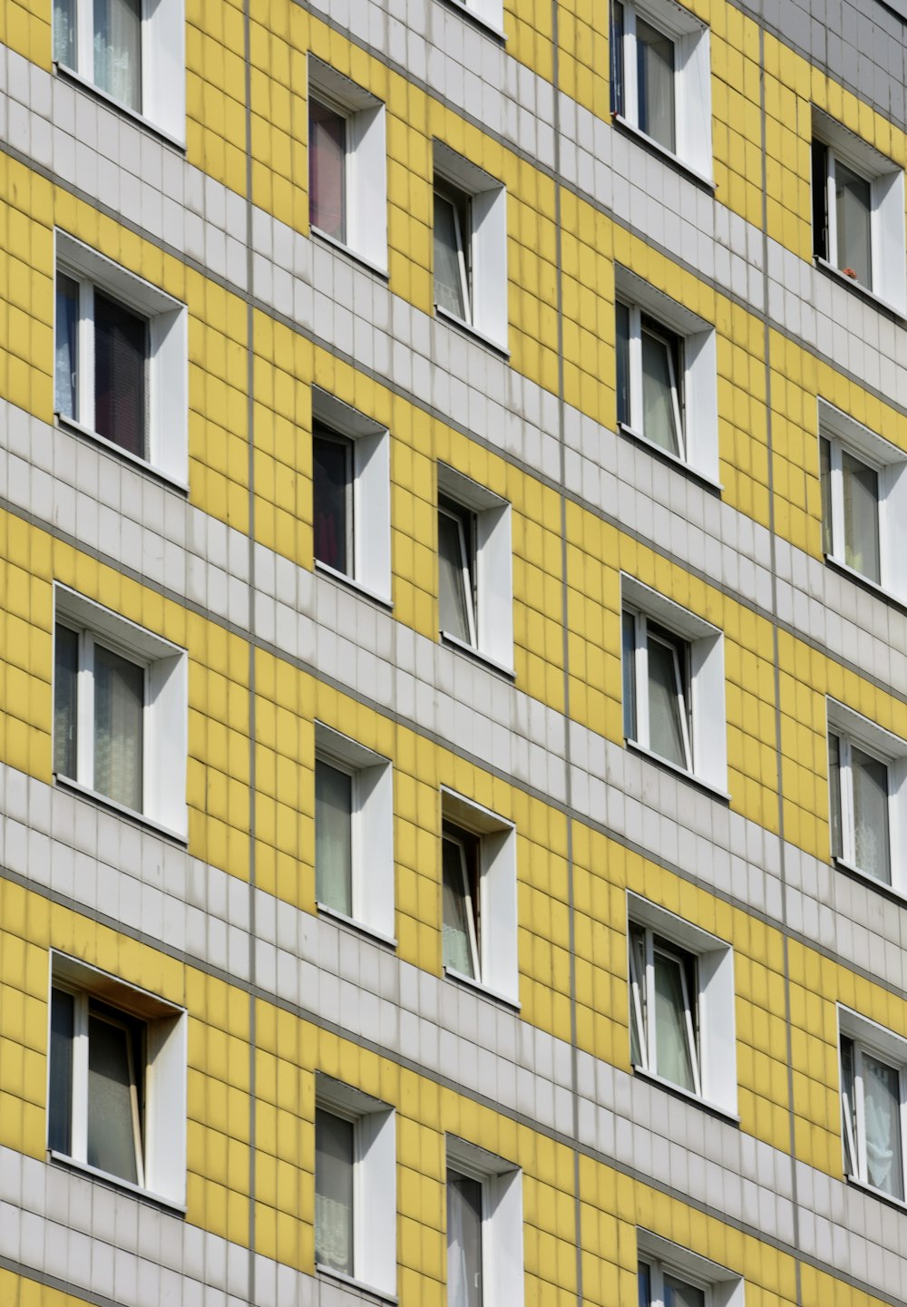 a yellow and grey building with many windows