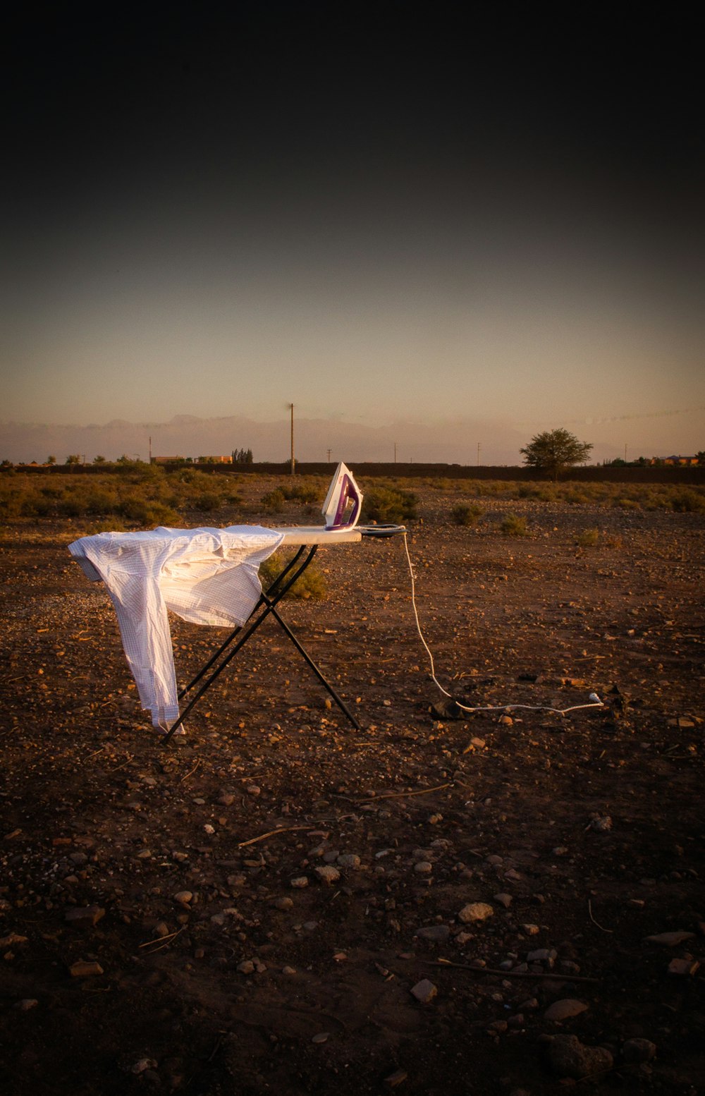 a white sheet on top of a chair in the middle of a field