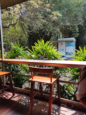 Guests seated attentively on wooden benches surrounded by greenery.