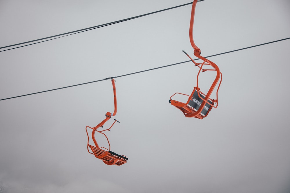 a couple of orange chairs sitting on top of power lines