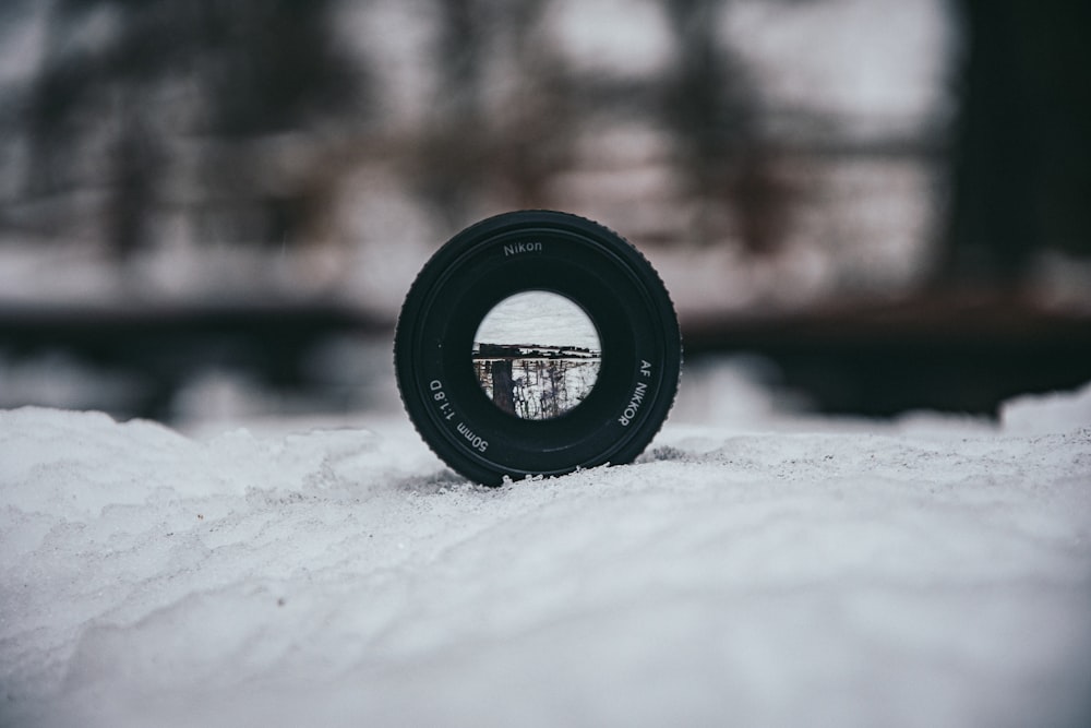 a camera lens sitting on top of a snow covered ground