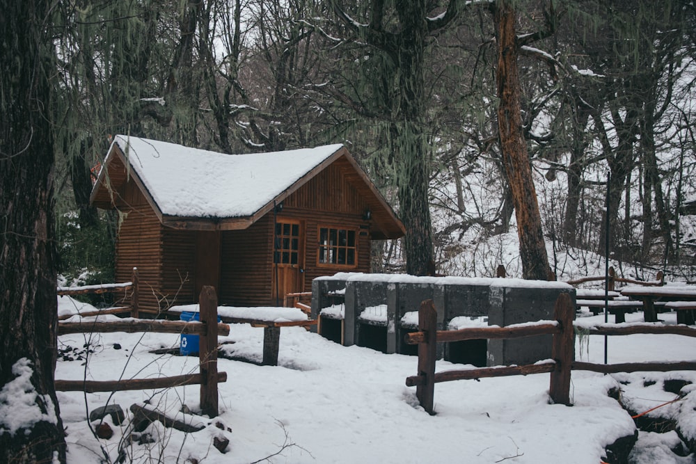 Una cabaña en el bosque cubierta de nieve