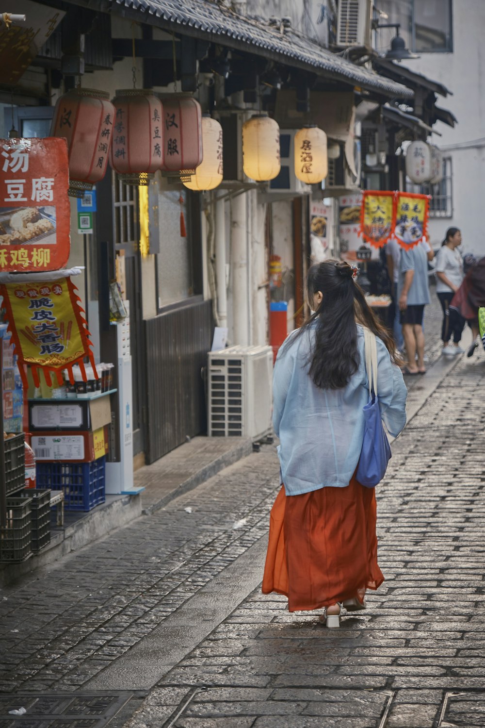 아시아 도시의 거리를 걷고 있는 여자